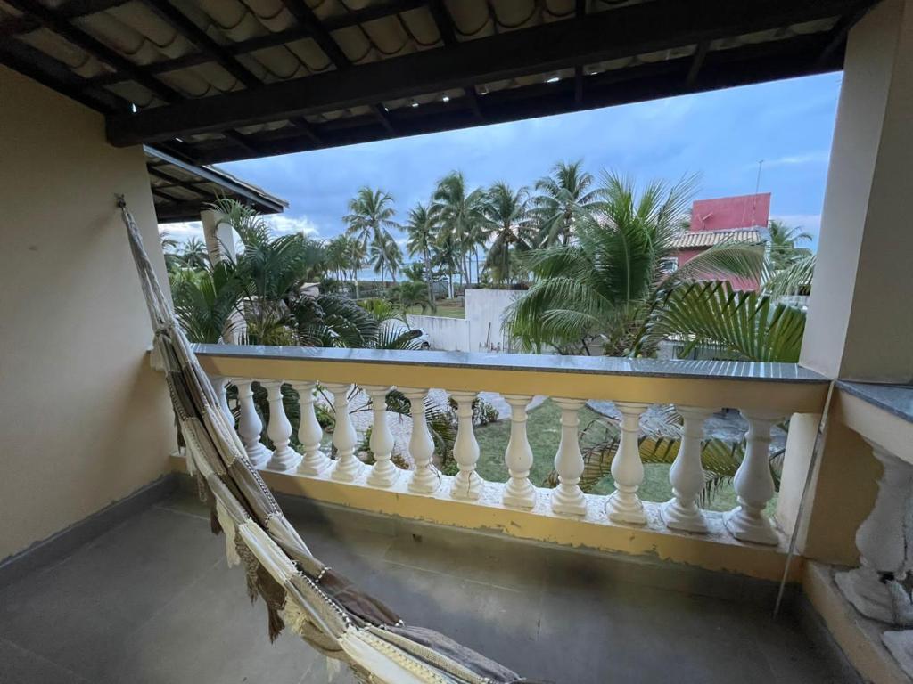 a balcony with a view of the palm trees at Village a Beira Mar na Praia da Espera in Itacimirim