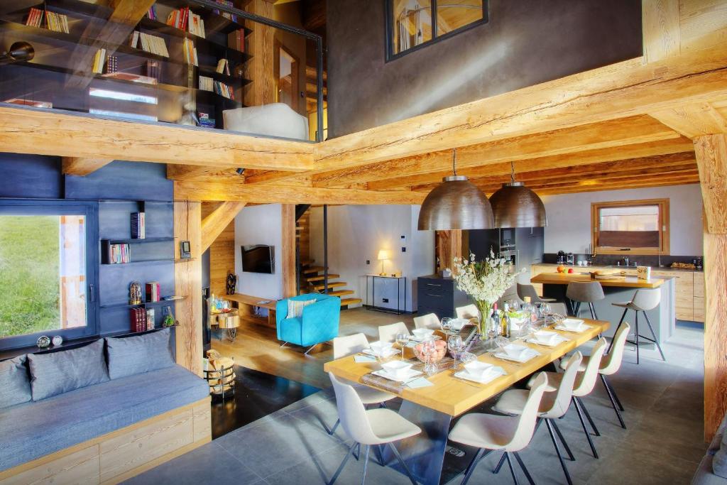 comedor y sala de estar con mesa y sillas en Chalet Stellaone - OVO Network, en La Clusaz