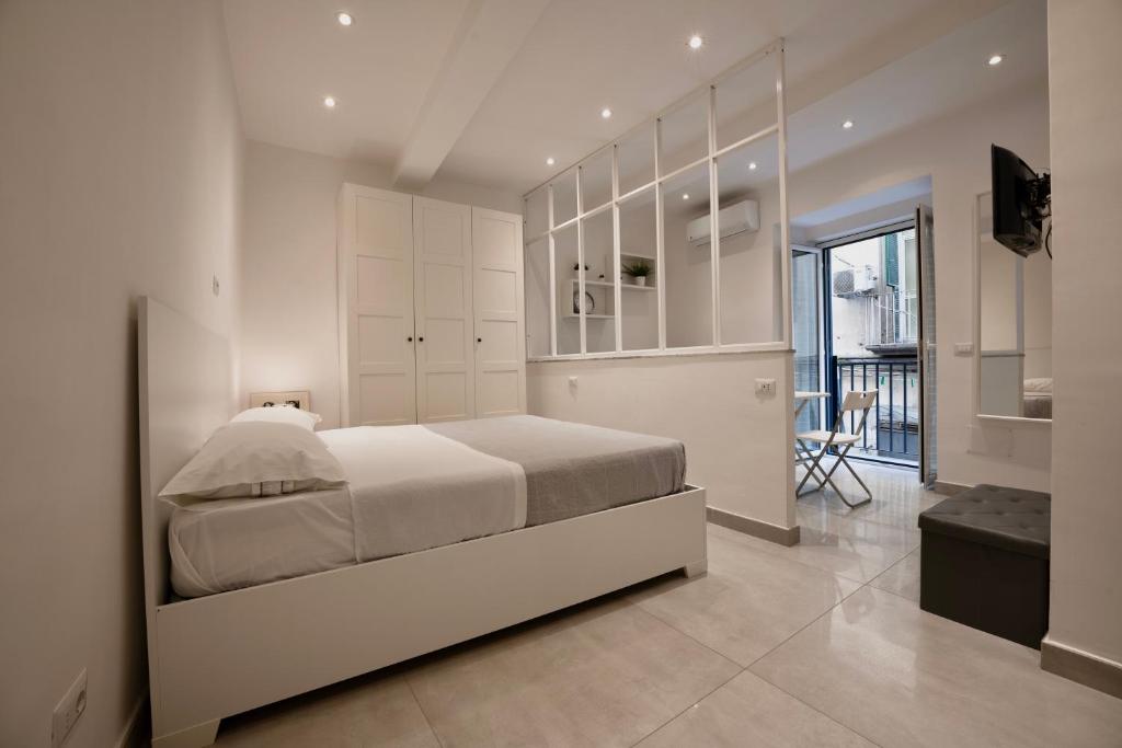 una camera bianca con un grande letto e un balcone di Casa Vacanze Santa Teresella 40 a Napoli
