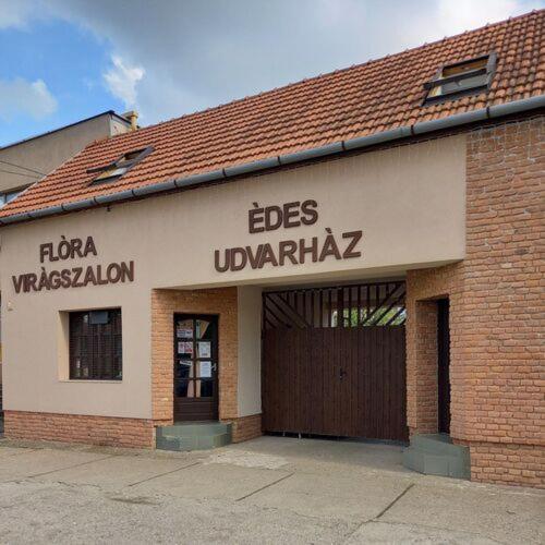 un edificio de ladrillo con una señal que readsles uwb imperialismo en Édes Udvarház, en Edelény