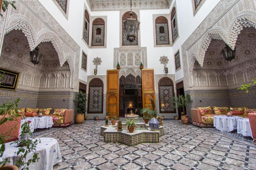 Habitación grande con mesas y sillas en un edificio en Pacha Palace en Fez