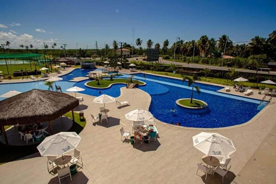 嘎林海斯港的住宿－Muro Alto condomínio clube，一个带遮阳伞和椅子的游泳池的度假酒店