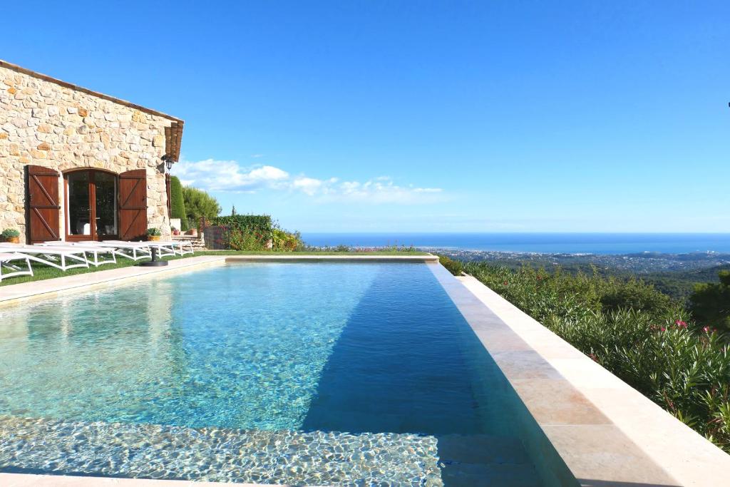 a swimming pool in front of a house with the ocean at Gite les Citronniers in Vence