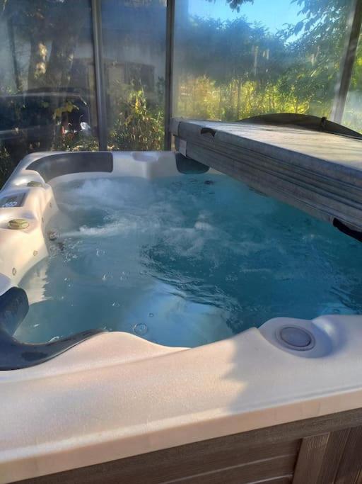 d'une baignoire avec de l'eau bleue dans la fenêtre. dans l'établissement Bas de villa, 2 terrasses, piscine, SPA, sauna..., à Neffes