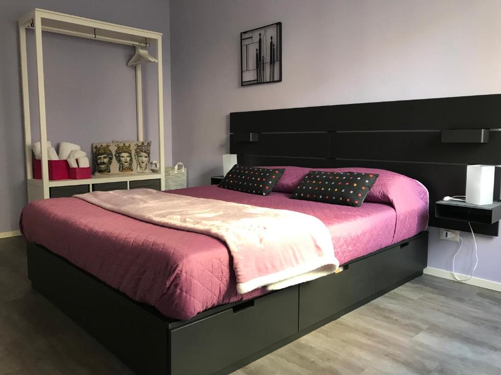 ein Schlafzimmer mit einem großen Bett mit einer rosa Decke in der Unterkunft Ade Home in Catania