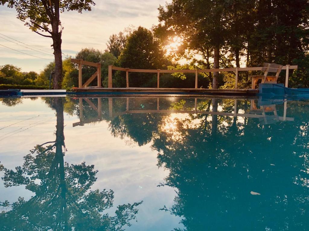a swimming pool with the reflection of the sun in the water at Ferienwohnung Bodensee 