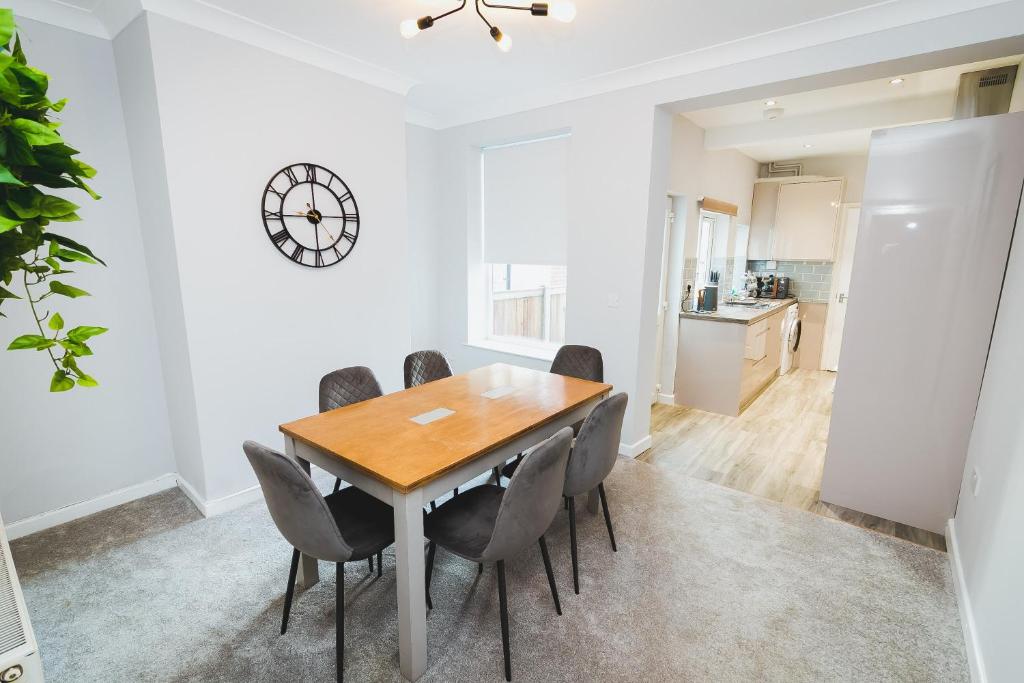 a dining room with a wooden table and chairs at Newly Refurbished House - 10 Minute Walk From City Centre in Norwich
