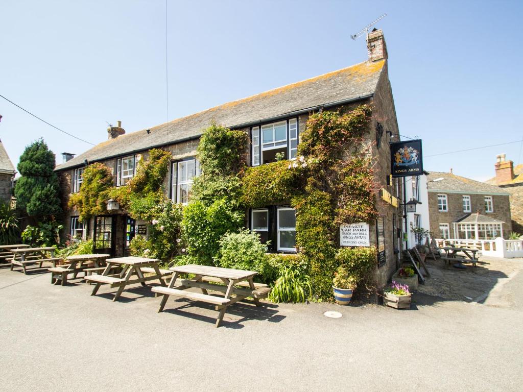 a building with picnic tables in front of it at Kings Arms in Penzance