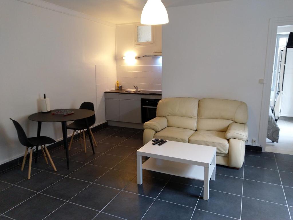 ein Wohnzimmer mit einem Sofa und einem Tisch in der Unterkunft O'Couvent - Appartement 44 m2 - 1 chambre - rdc ext in Salins-les-Bains