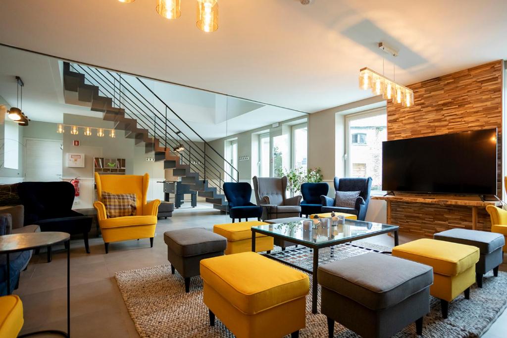 a lobby with chairs and tables and a tv at Enjoytoday vakantiewoning 45 in Oudenaarde