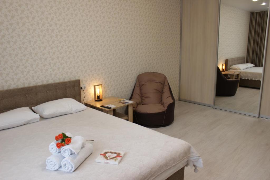 een hotelkamer met een bed, een stoel en een spiegel bij Квартира в Вышгороде для души in Vyshhorod
