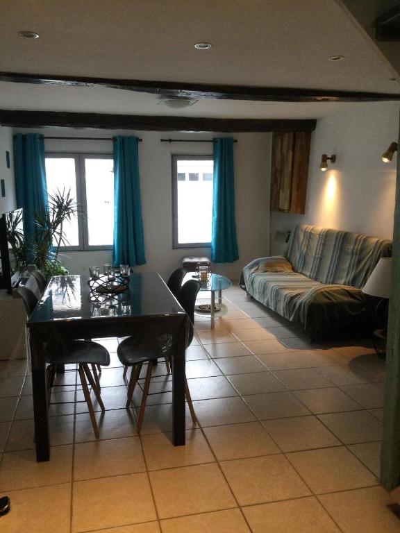 un salon avec une table et un canapé dans l'établissement Hébergement à l'Orée des Champs, à Rethel