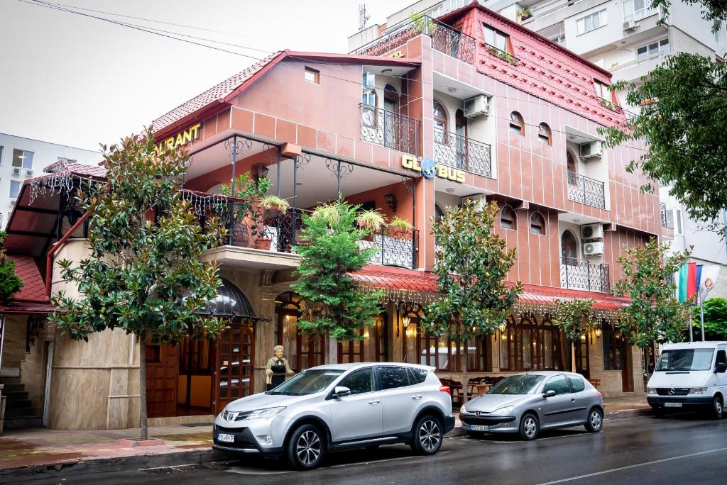 two cars parked in front of a building at Globus Hotel in Plovdiv