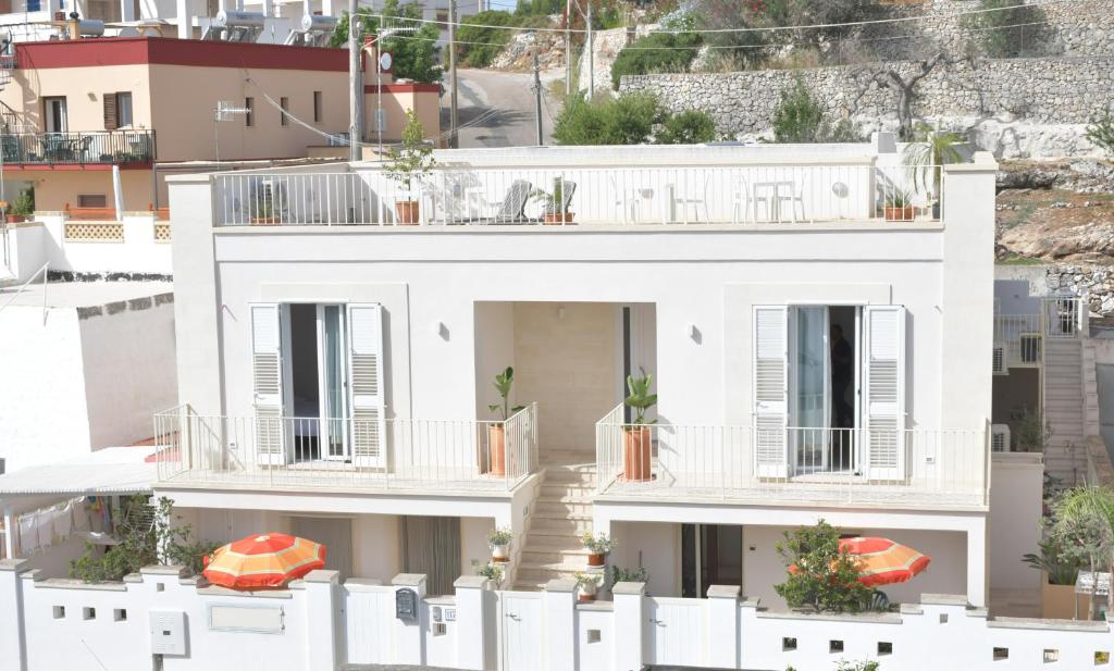 Casa blanca con balcones y valla blanca en Estatesalento, en Leuca