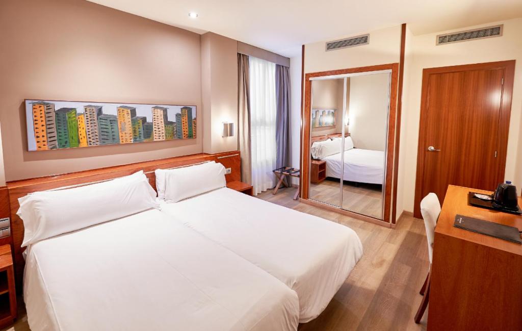 um quarto de hotel com uma cama branca e um espelho em Garbi Millenni em Barcelona