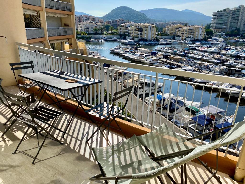 a balcony with a table and chairs and a marina at Appartement lumineux 6 places avec vue sur Marina in Mandelieu-la-Napoule