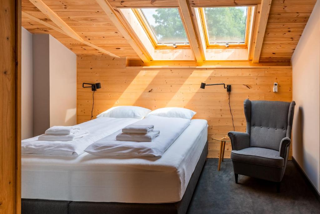 ein Schlafzimmer mit einem Bett und einem Stuhl in der Unterkunft Dom Gościnny Maximus in Lubomierz