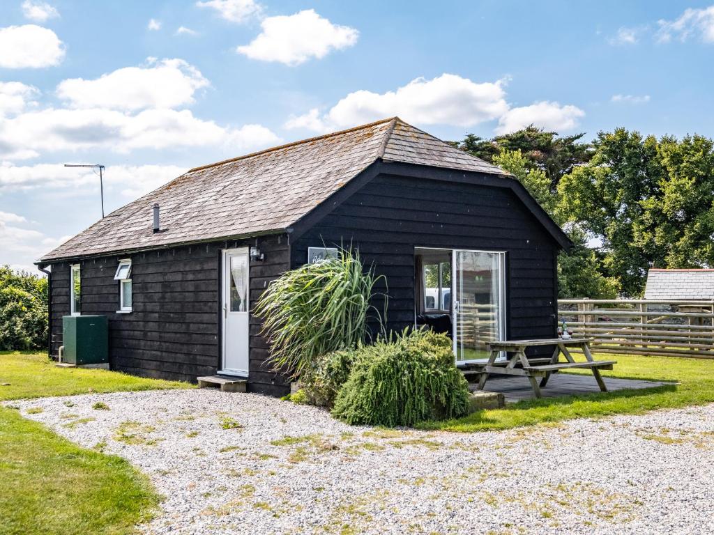 a small black shed with a picnic table in front of it at Atlantic Lodge in Port Isaac