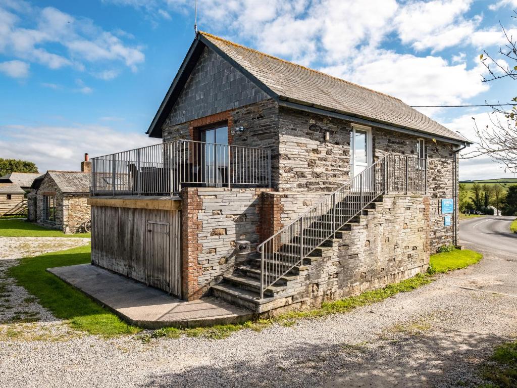 un edificio in mattoni con una scala sul lato di Swallow Cottage, Trewetha Farm a Port Isaac