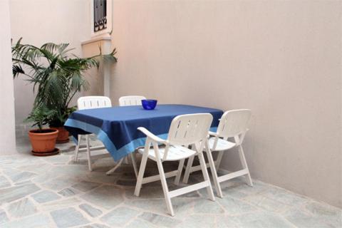 a blue table with white chairs and a blue bowl on it at Stone Mansion House in Skopelos Town