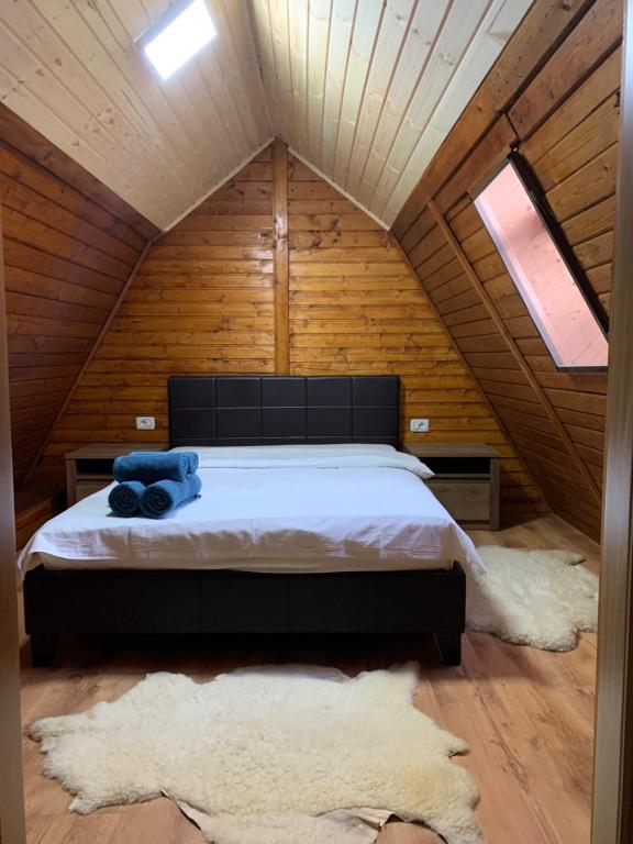 Poiana ŢapuluiにあるLucomi Chalet - For groups - 5 bedroomsの木造キャビン内のベッド1台が備わるベッドルーム1室を利用します。