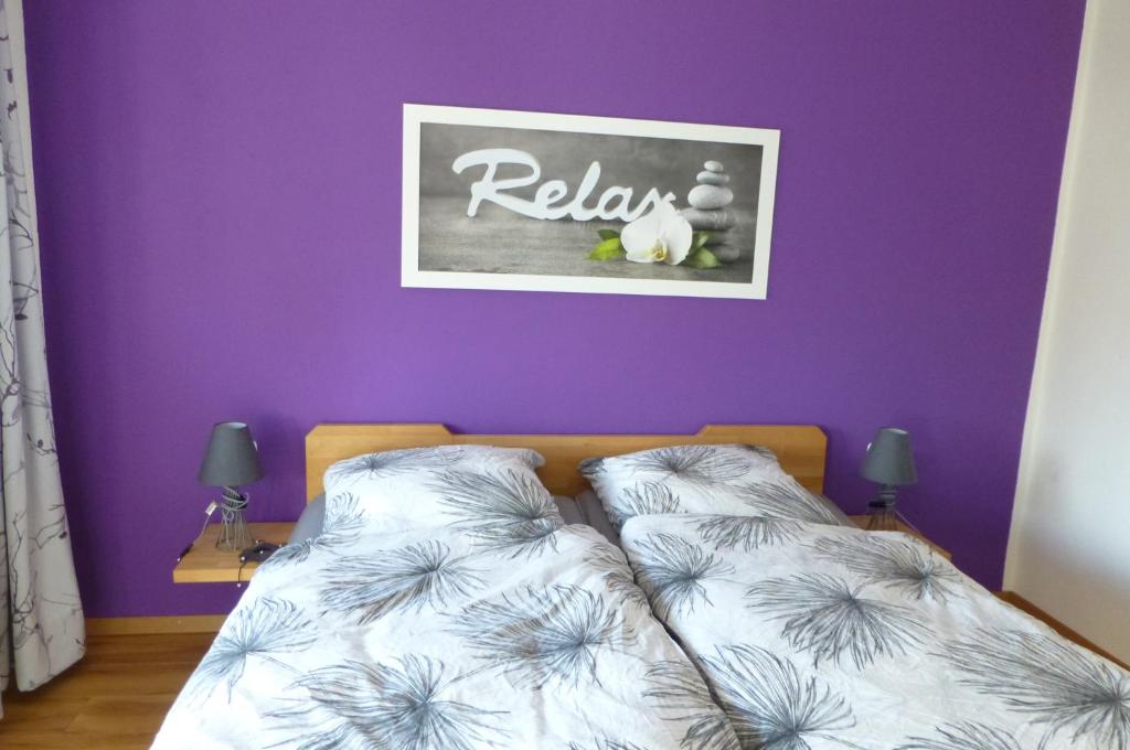 - une chambre avec des murs violets et 2 lits avec des oreillers dans l'établissement Ferienwohnung Lorke, à Thiersheim