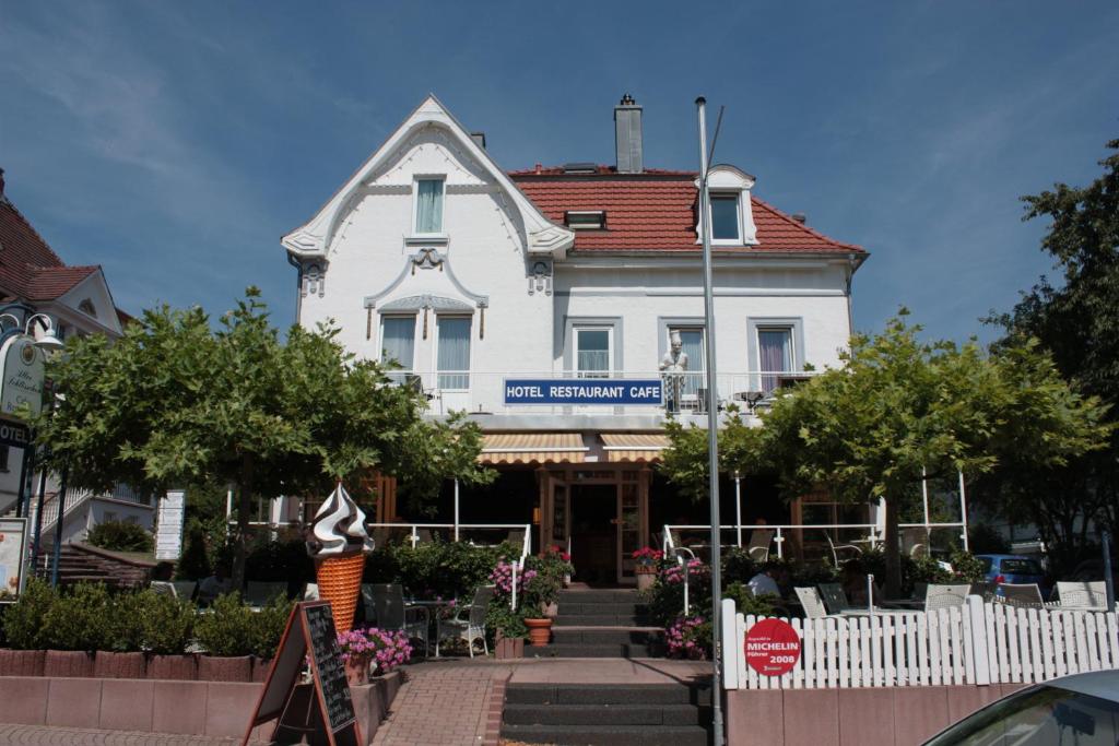une maison blanche avec un panneau à l'avant dans l'établissement Hotel AlleeSchlößchen, à Bad Wildungen