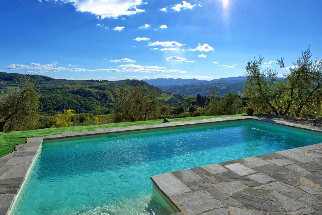uma piscina com vista para as montanhas em San Guido by PosarelliVillas em Pelago