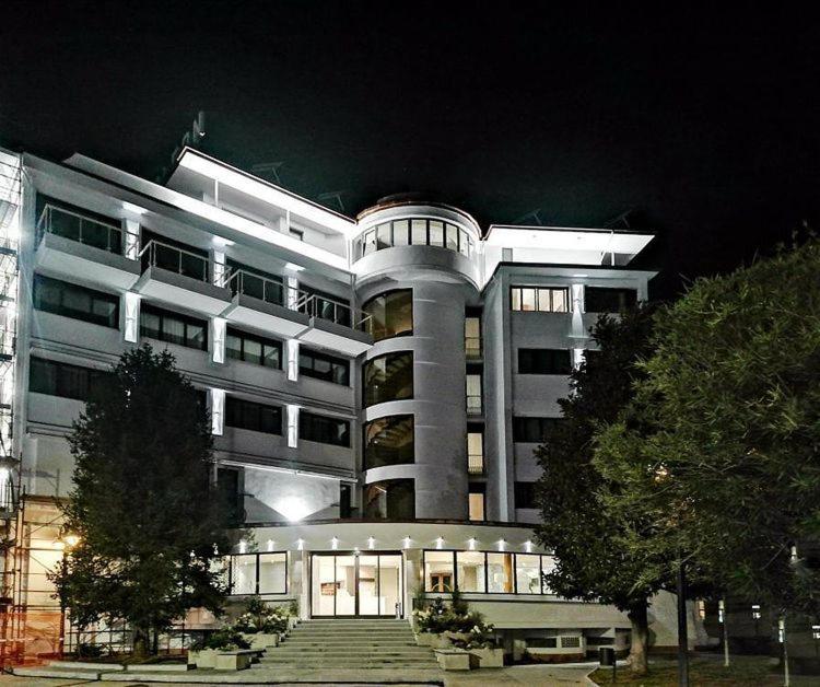 a large building with stairs in front of it at night at Hotel Napoleon in Lucca