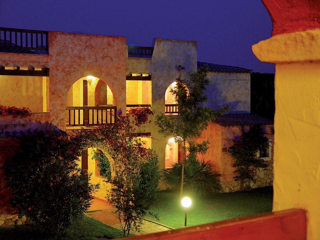 a large building with a courtyard at night at iGV Club Santagiusta in Castiadas