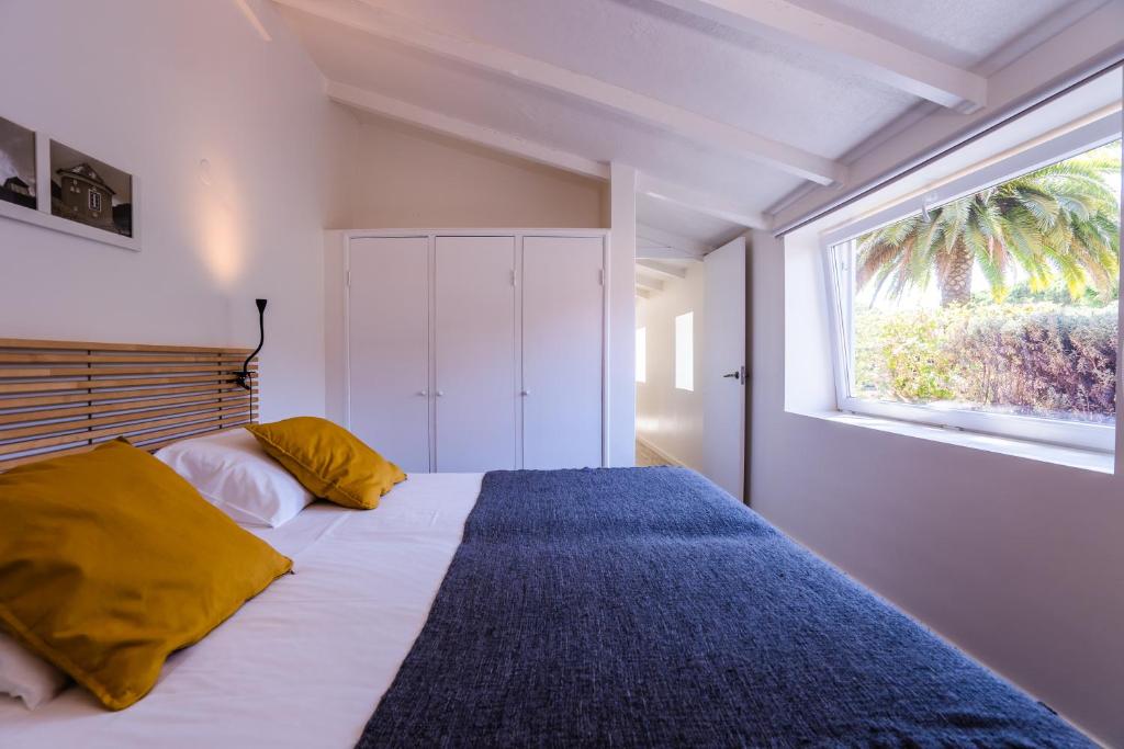 a bedroom with a large bed with a window at Quinta da Bicuda in Cascais