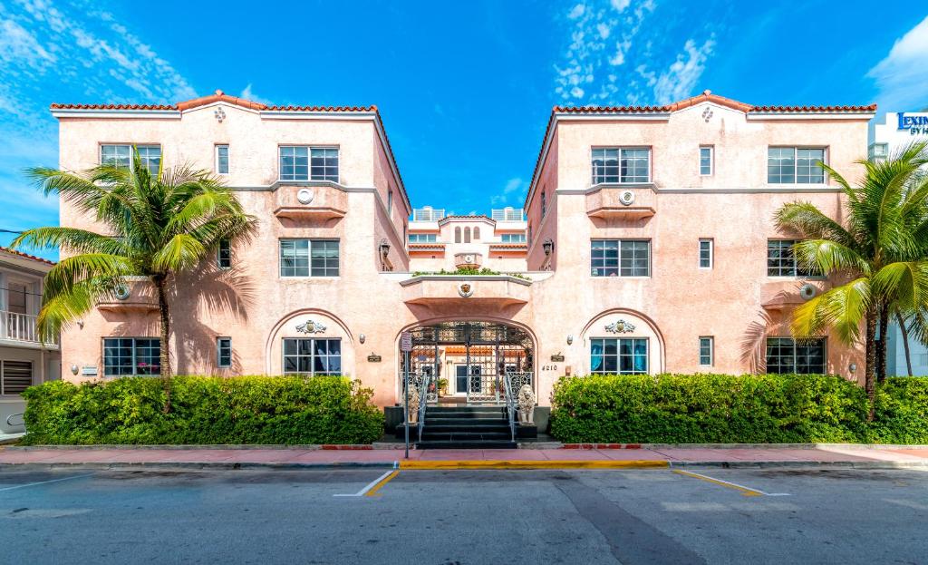 a large building with palm trees in front of it at Secret Garden Miami Beach in Miami Beach