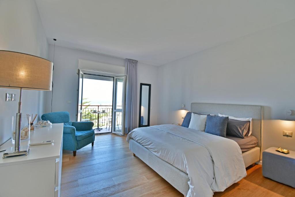 - une chambre avec un lit et une chaise bleue dans l'établissement Luxury Suites Casa di Joy in Cefalù, à Cefalù