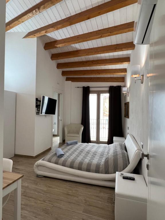 una camera con un grande letto e un soffitto in legno di L’ANGELO BIANCO a Pula