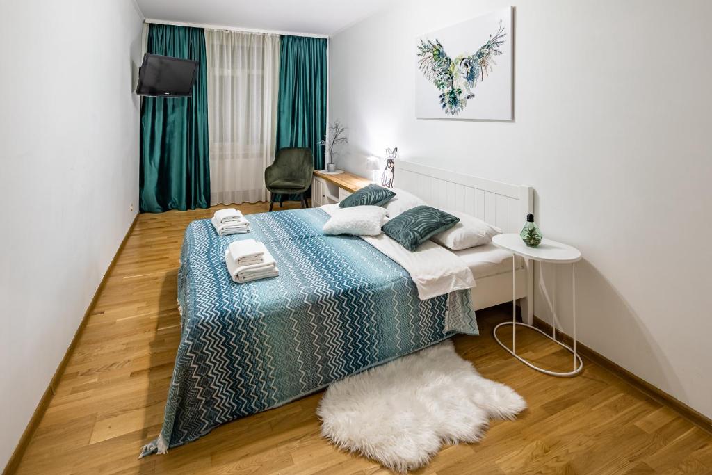 ein Schlafzimmer mit einem Bett und einem Tisch mit einem Teppich in der Unterkunft The MAIN square! 2 separated bedrooms, balcony in Lwiw