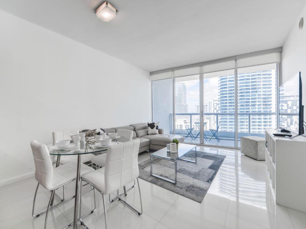 een witte woonkamer met een tafel en een bank bij Marvelous apartment in Brickell in Miami
