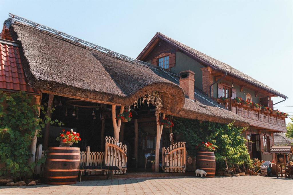 a house with a thatched roof with flowers in front at Gagauz Sofrasi in Congaz