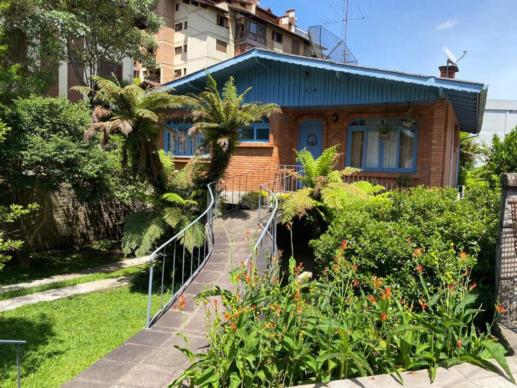 una casa con una valla frente a un jardín en Casa da Vó Diva no Centro de Gramado en Gramado