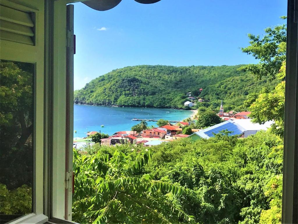 a view of a bay from a window at APPARTEMENT COLIBRI , Les Anses d 'Arlet in Les Anses-dʼArlets