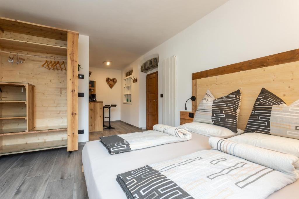 two beds in a room with wooden walls at Agritur E-Cinque in Salorno
