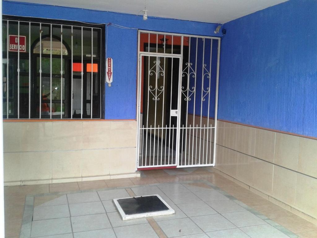a room with a door in a building with blue walls at Hotel San Andres in Xalapa