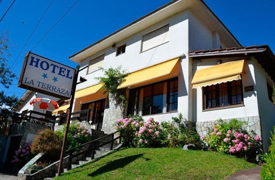 un hotel con un cartel frente a un edificio en el Hotel La Terraza en Villa Gesell