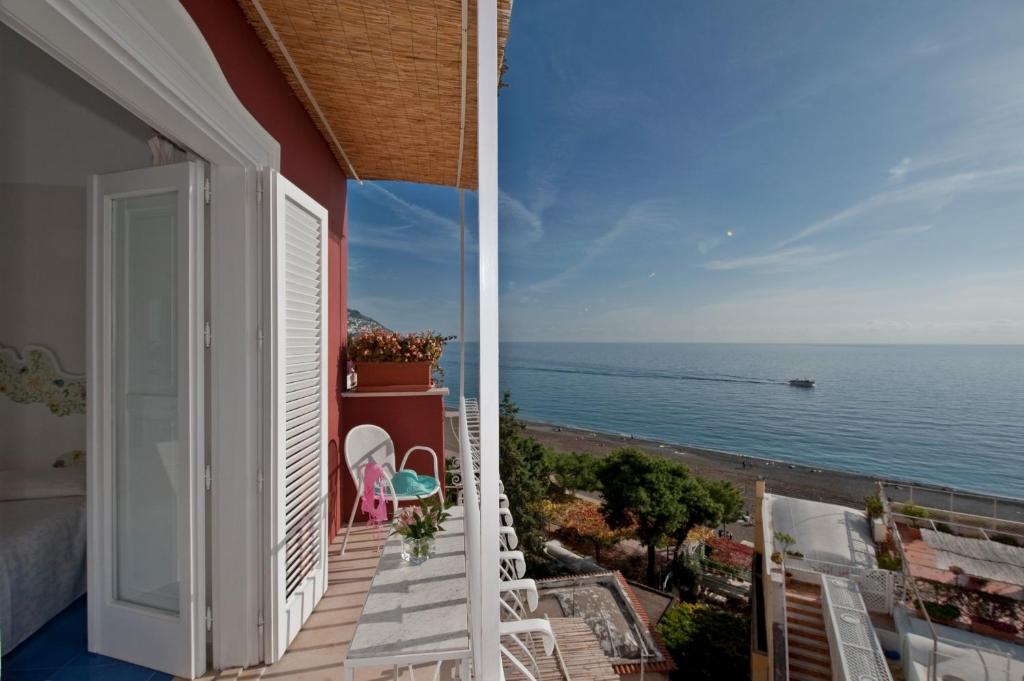 
a balcony overlooking a beach with a view of the ocean at Villa La Tartana in Positano
