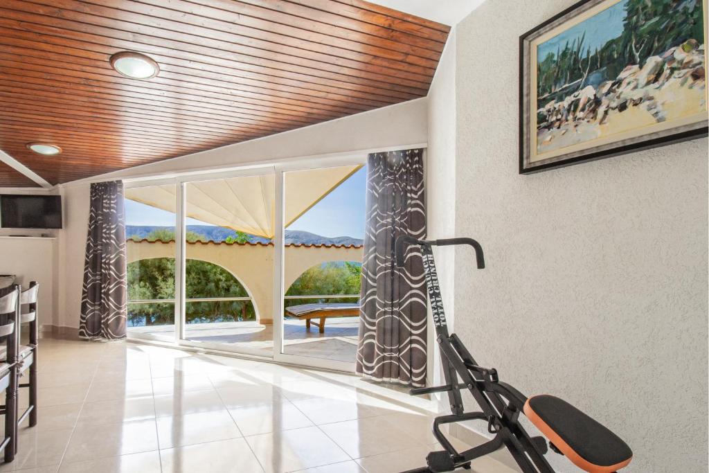 a gym with a treadmill in a room with a large window at Galapagus privat beach & boat dock in Metajna