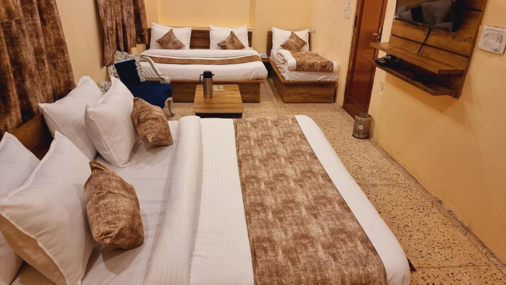 a bedroom with two beds with pillows at Hotel Babua Hyness By Avadhesh Group Of Hospitality in Haridwār
