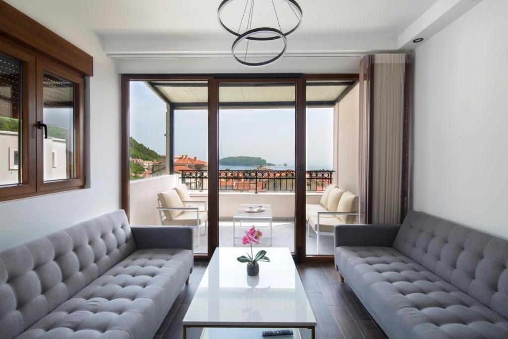 uma sala de estar com dois sofás e uma mesa em Villa Lazy Hill em Budva