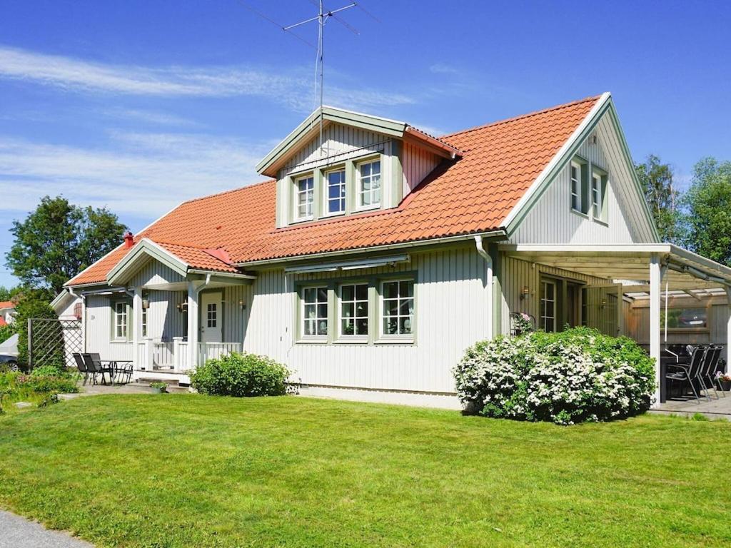 una casa blanca con techo naranja en 9 person holiday home in SOLLENTUNA, en Sollentuna