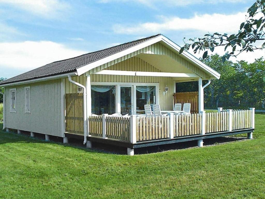 une petite maison avec des chaises sur une terrasse dans un champ dans l'établissement 4 person holiday home in Byxelkrok, à Byxelkrok