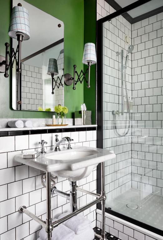 a white bathroom with a sink and a shower at The Randolph Hotel Oxford, a Graduate by Hilton Hotel in Oxford