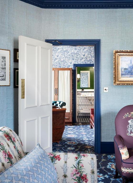 an open door to a room with a chair and a table at The Randolph Hotel Oxford, a Graduate by Hilton Hotel in Oxford